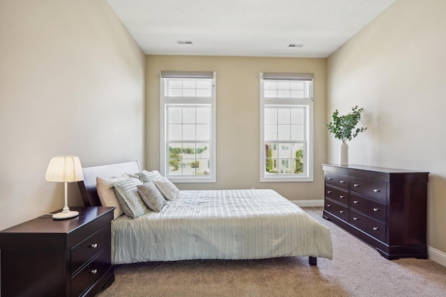 bedroom featuring visible vents, baseboards, and carpet