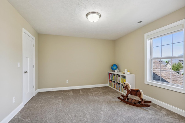 playroom featuring baseboards, carpet floors, and a textured ceiling