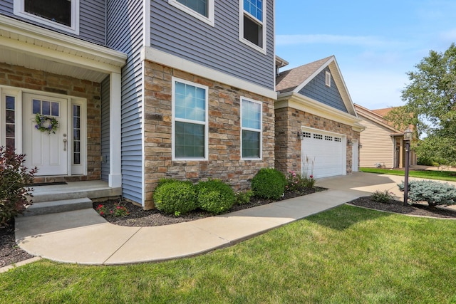 property entrance featuring a garage, stone siding, and a yard