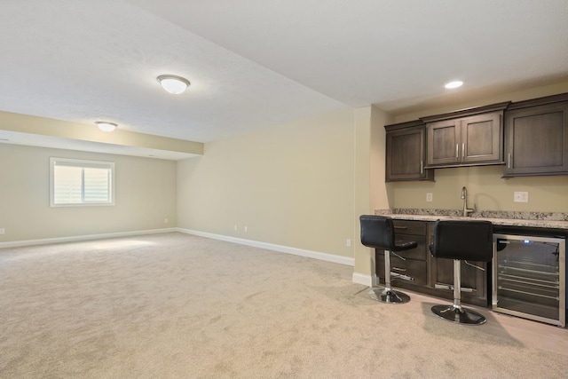 bar featuring baseboards, wine cooler, light carpet, indoor wet bar, and recessed lighting