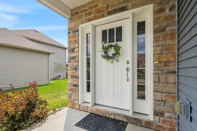 property entrance with brick siding, stone siding, and a yard