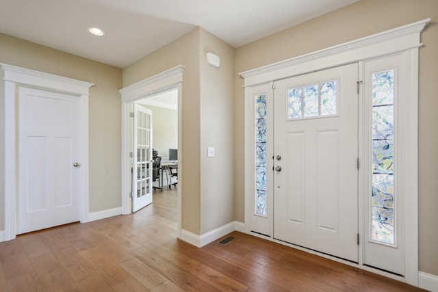 foyer entrance with recessed lighting, visible vents, baseboards, and hardwood / wood-style flooring