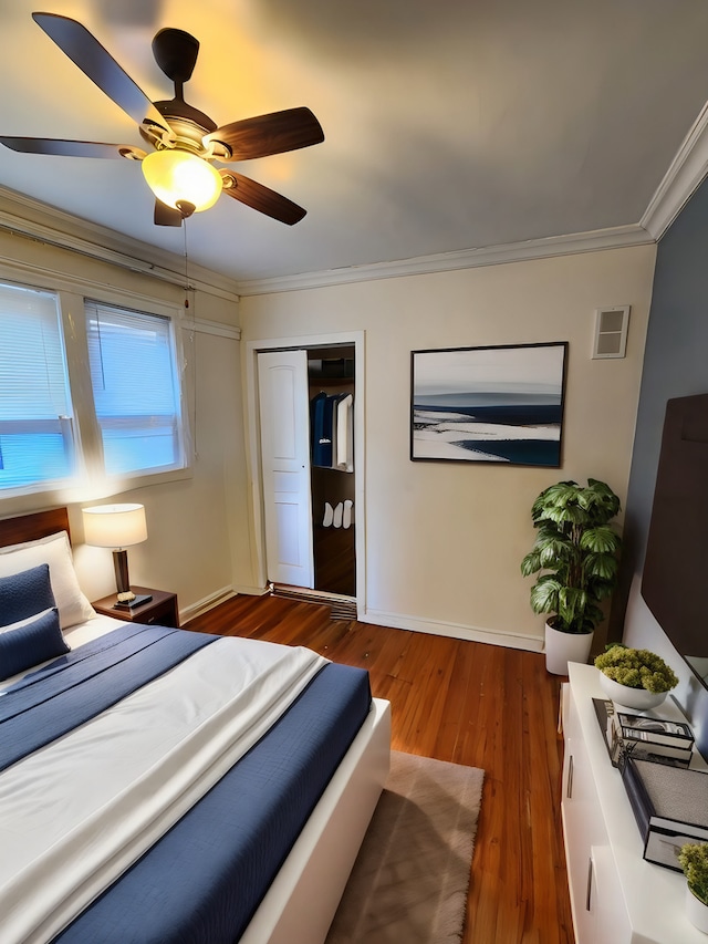 bedroom featuring ceiling fan, a closet, crown molding, and dark hardwood / wood-style floors