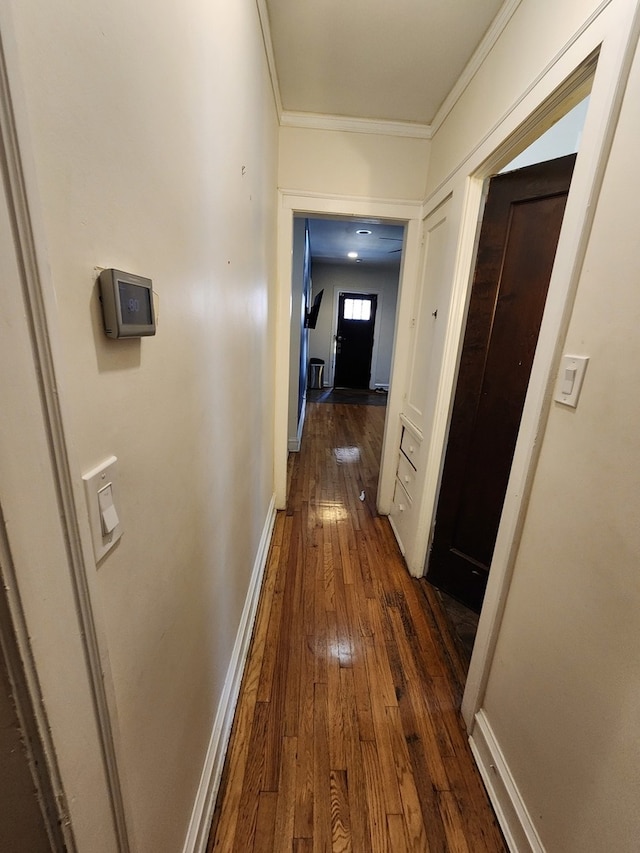 corridor with dark hardwood / wood-style floors and crown molding