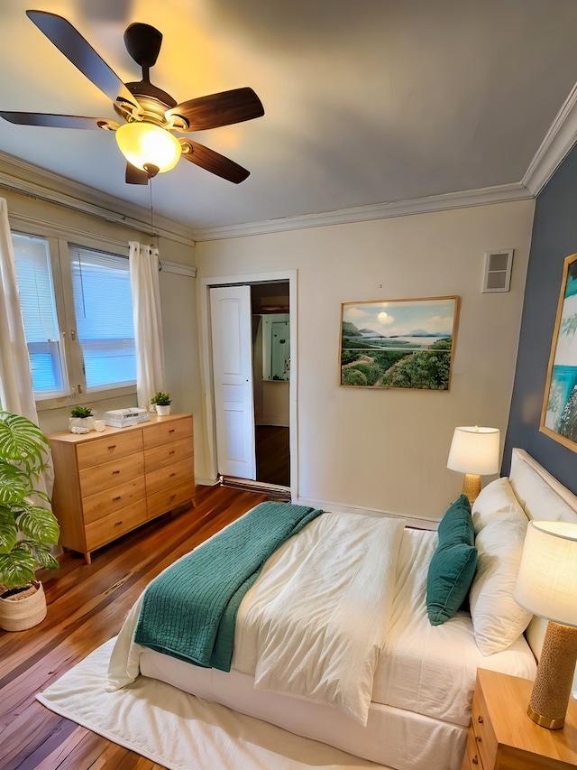 bedroom with hardwood / wood-style floors, ceiling fan, crown molding, and a closet