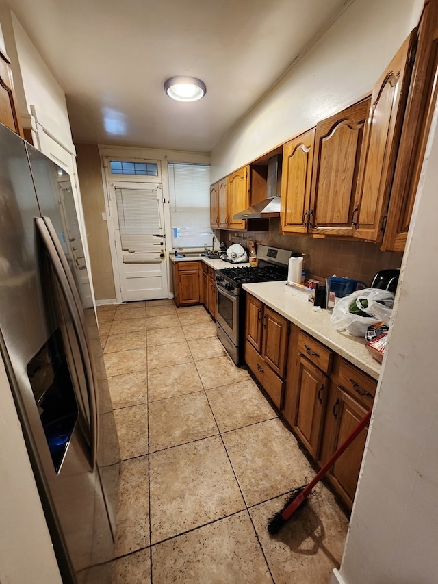 kitchen with decorative backsplash, appliances with stainless steel finishes, and wall chimney range hood