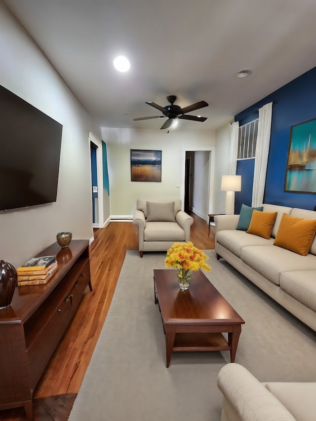 living room with hardwood / wood-style flooring and ceiling fan