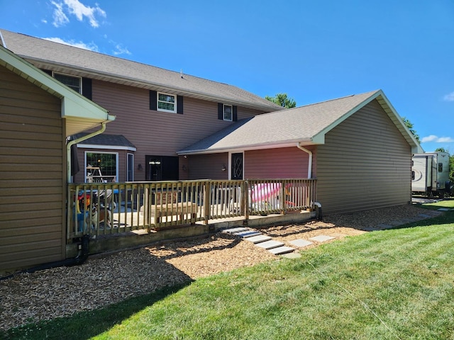 rear view of house with a yard and a deck