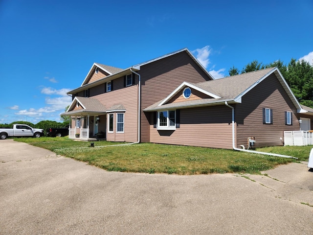 view of front of property featuring covered porch and a front yard