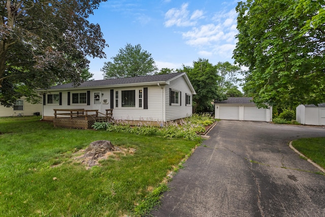 view of front of property with a storage unit, a garage, a deck, and a front yard