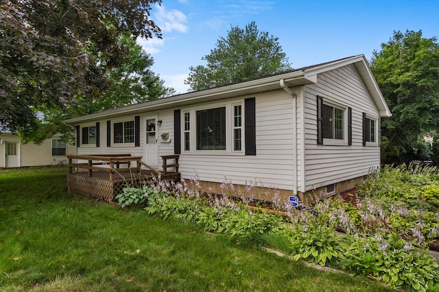 back of house featuring a lawn and a deck