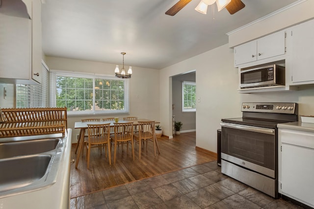 kitchen featuring decorative light fixtures, stainless steel appliances, white cabinetry, and a healthy amount of sunlight