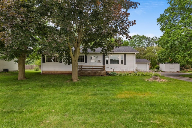 view of front of home featuring a shed, a front lawn, and a wooden deck