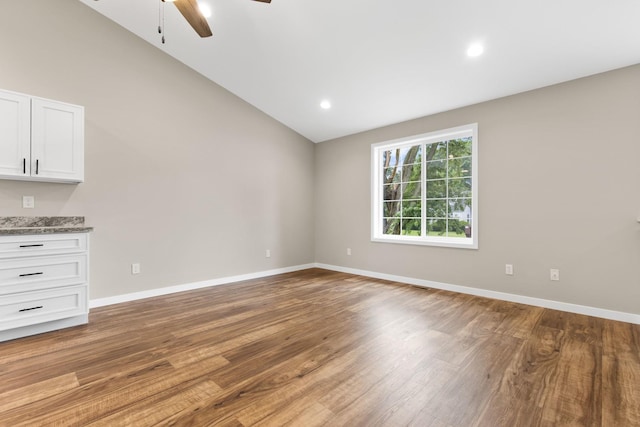 spare room featuring hardwood / wood-style flooring, ceiling fan, and vaulted ceiling