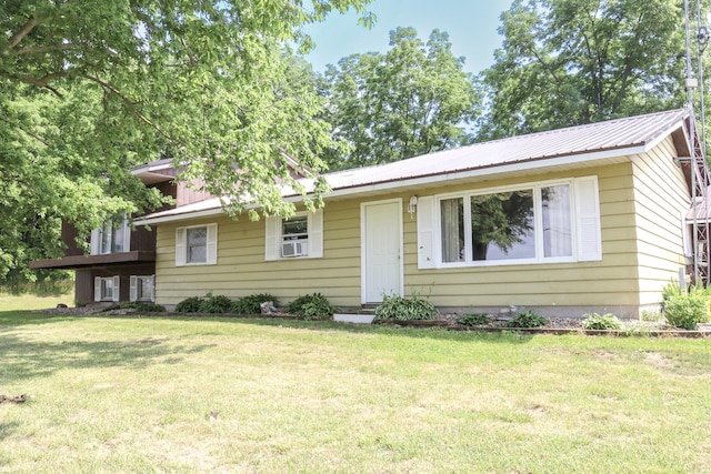 view of front of home featuring cooling unit and a front yard