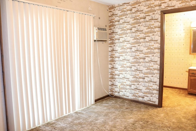 unfurnished bedroom with light colored carpet and an AC wall unit