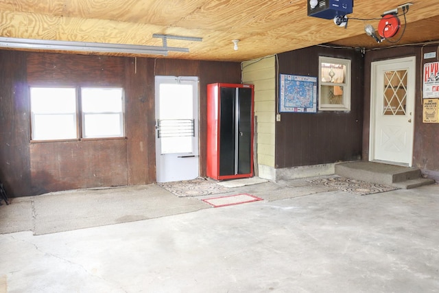 garage featuring a garage door opener and wooden walls