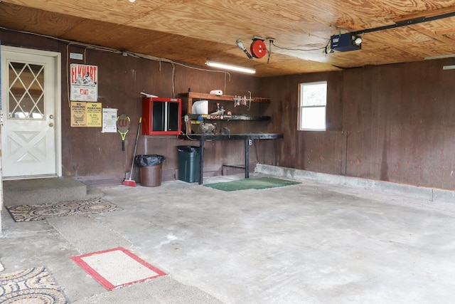 garage featuring wood walls and a garage door opener