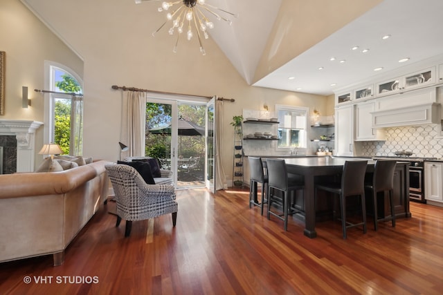 living room with a fireplace, a chandelier, dark hardwood / wood-style flooring, and lofted ceiling