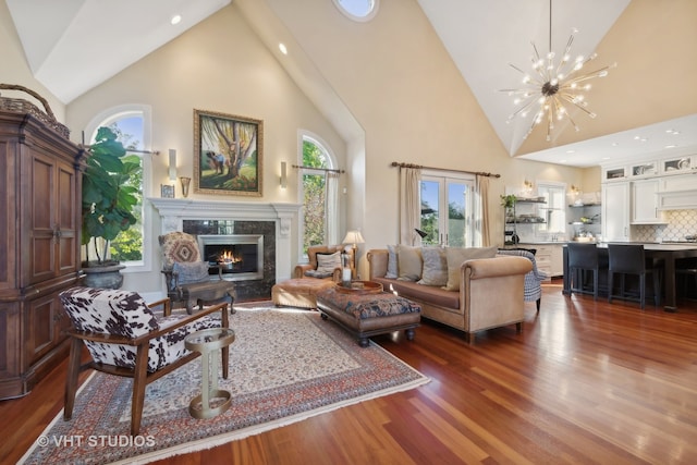 living room with dark hardwood / wood-style floors, a high end fireplace, high vaulted ceiling, and a wealth of natural light