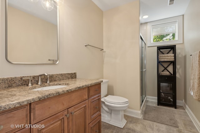 bathroom featuring tile patterned flooring, vanity, toilet, and a shower with door