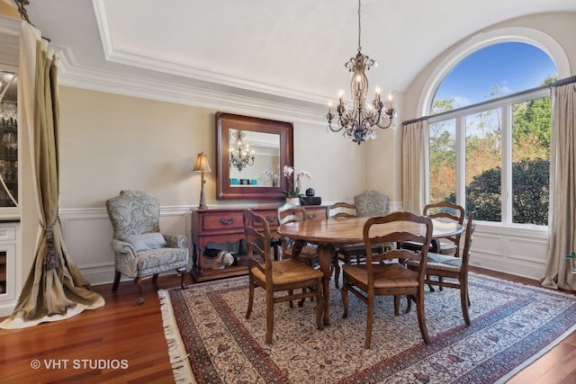 dining area with ornamental molding, an inviting chandelier, and dark wood-type flooring