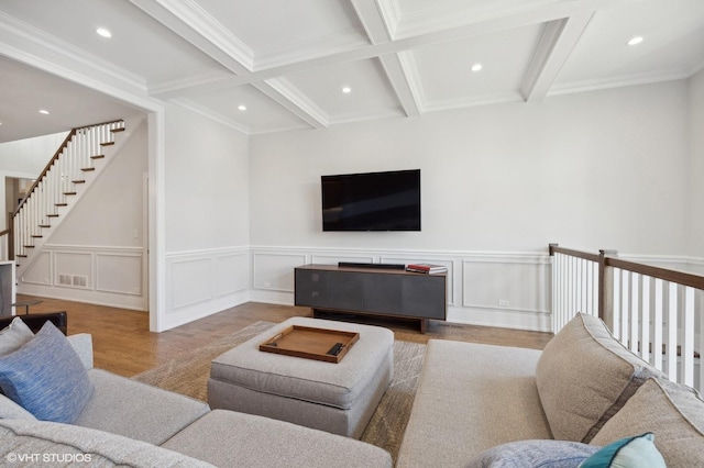 living room featuring beam ceiling, ornamental molding, light hardwood / wood-style flooring, and coffered ceiling