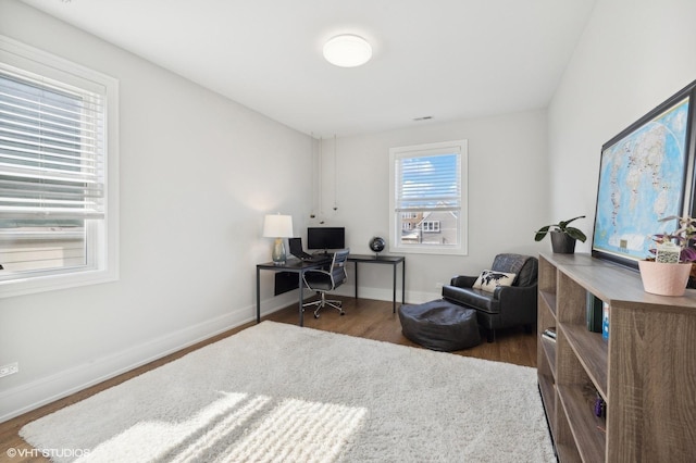 home office featuring dark hardwood / wood-style floors and a healthy amount of sunlight