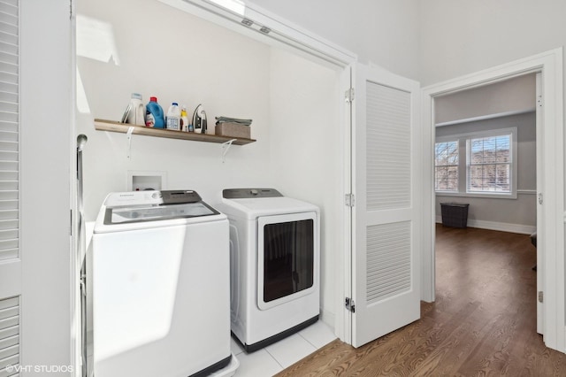 laundry room with washer and clothes dryer and hardwood / wood-style flooring