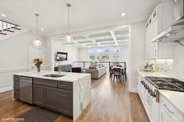 kitchen featuring sink, coffered ceiling, wall chimney range hood, beamed ceiling, and white cabinets