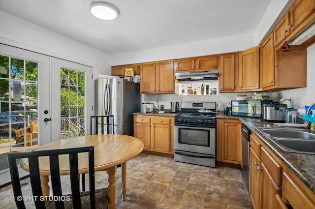 kitchen featuring stainless steel appliances, sink, and dark stone counters