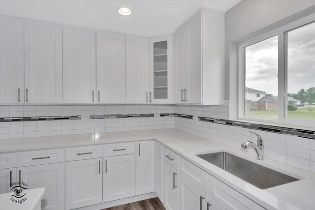 kitchen with sink, white cabinets, backsplash, and hardwood / wood-style floors