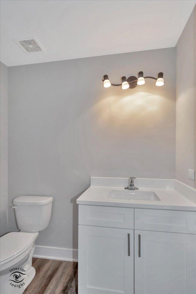 bathroom featuring toilet, vanity, and hardwood / wood-style flooring