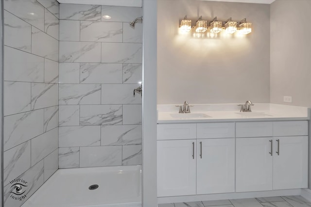 bathroom with tiled shower, double vanity, and tile flooring