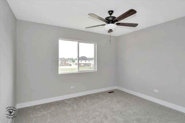 carpeted spare room with ceiling fan