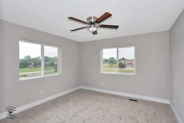 unfurnished room featuring a wealth of natural light, ceiling fan, and carpet floors