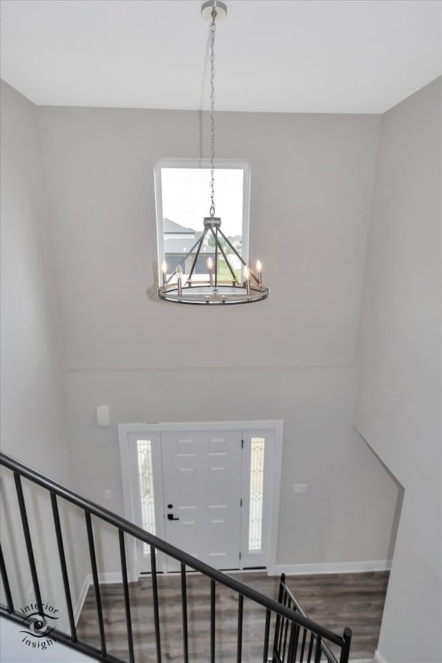 foyer with an inviting chandelier, plenty of natural light, and hardwood / wood-style floors