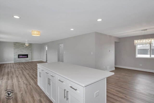 kitchen featuring open floor plan, light wood finished floors, white cabinetry, and a center island