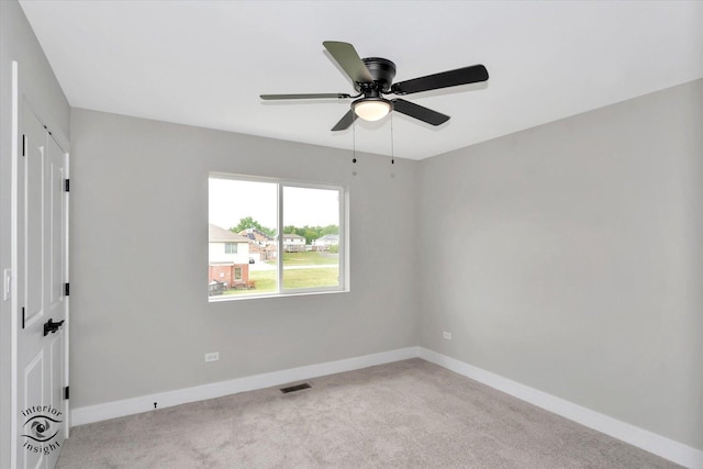 spare room featuring carpet floors, visible vents, ceiling fan, and baseboards