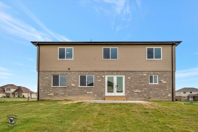 rear view of house featuring a patio area, french doors, brick siding, and a yard