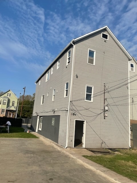 view of side of home featuring a balcony and a lawn