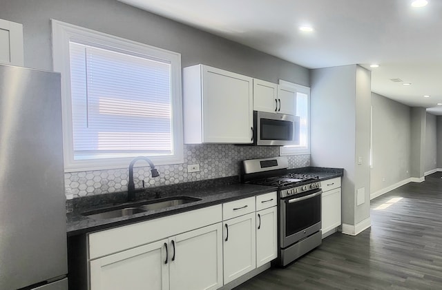 kitchen featuring tasteful backsplash, dark hardwood / wood-style flooring, sink, stainless steel appliances, and white cabinets