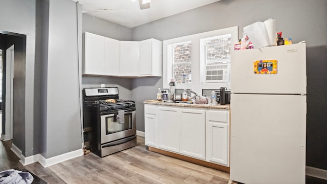 kitchen with white fridge, gas stove, light hardwood / wood-style floors, and white cabinetry