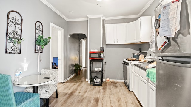 kitchen featuring stainless steel fridge, light hardwood / wood-style flooring, range with gas stovetop, crown molding, and white cabinetry