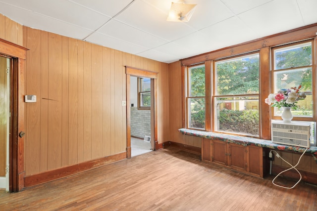 spare room with wood walls, cooling unit, and hardwood / wood-style floors