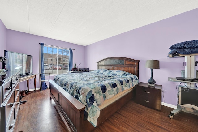 bedroom with dark hardwood / wood-style floors and a textured ceiling