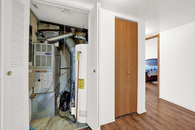 utility room featuring water heater and heating unit