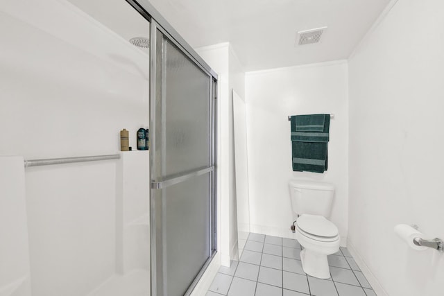 bathroom featuring tile patterned flooring, a shower with shower door, and toilet