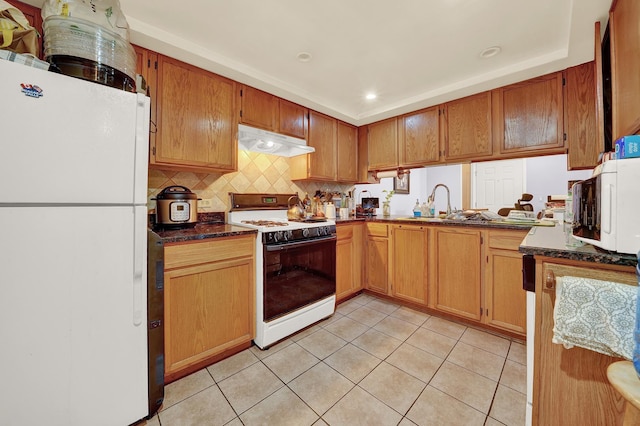 kitchen featuring backsplash, white appliances, and light tile patterned floors