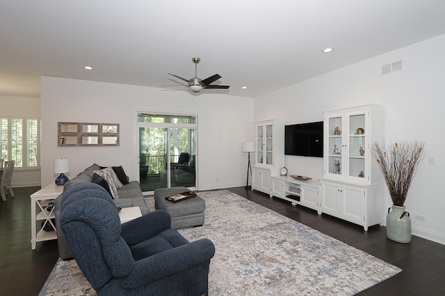 living room featuring ceiling fan and dark wood-type flooring